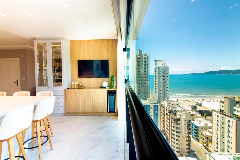 Modern Pattaya condominium interior with floor-to-ceiling windows and views towards the sea.